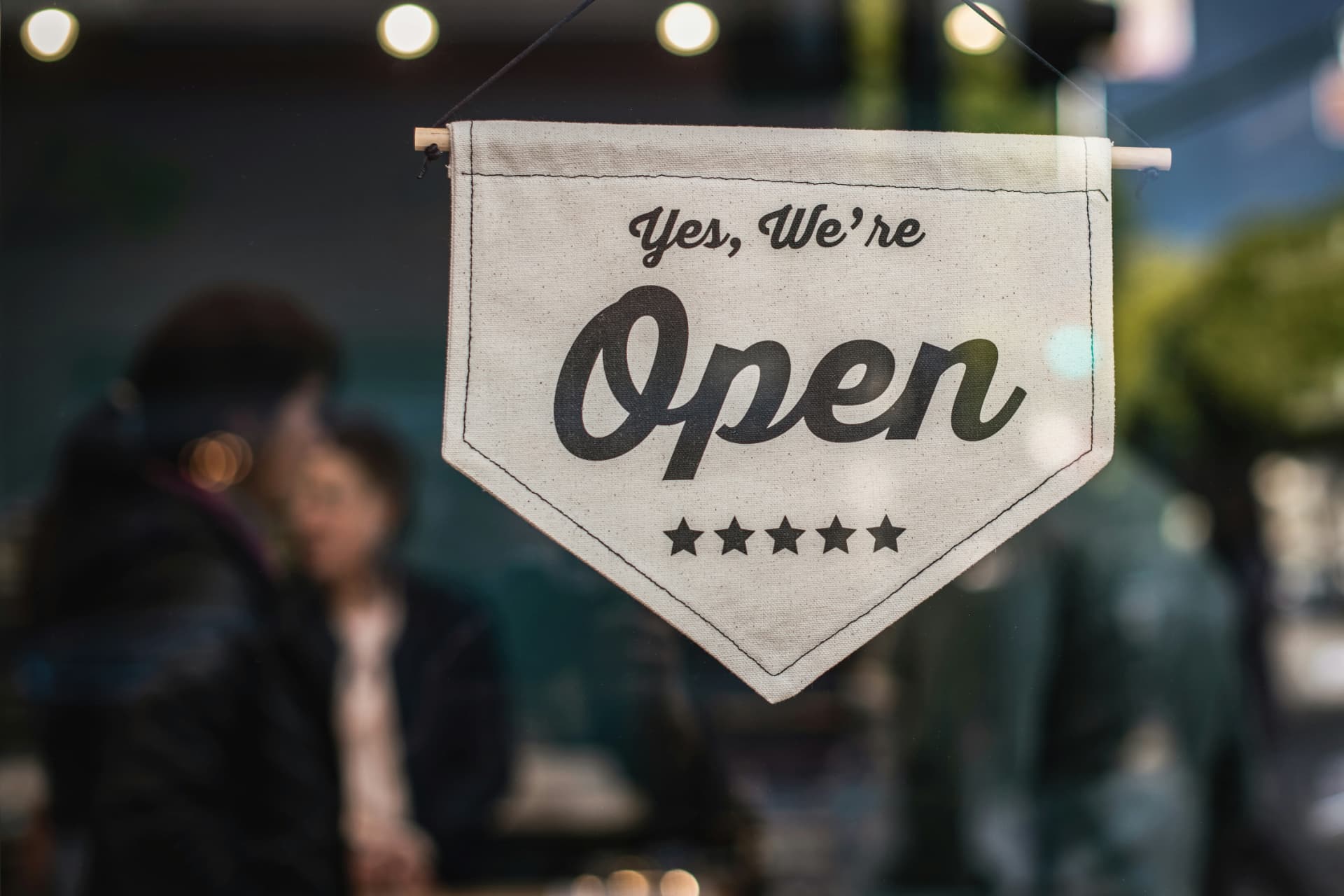 Canvas sign in a storefront window reading Yes, We're Open
